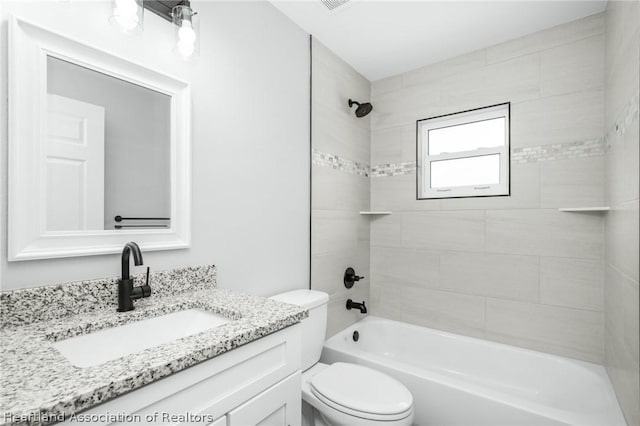 full bathroom with toilet, vanity, and tiled shower / bath