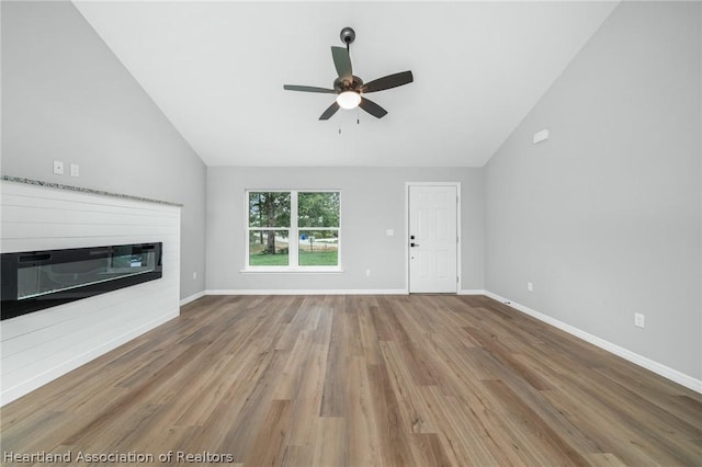 unfurnished living room with ceiling fan, high vaulted ceiling, and wood-type flooring