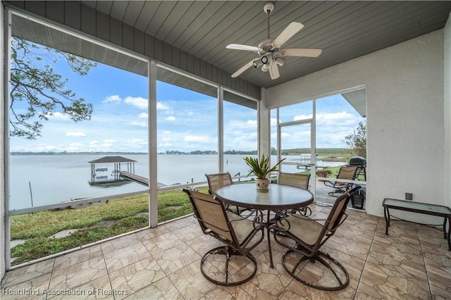 sunroom / solarium featuring a water view and ceiling fan