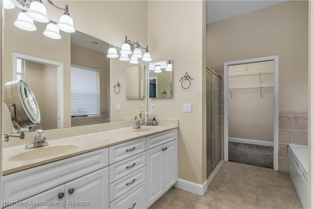 bathroom featuring tile patterned floors, shower with separate bathtub, vanity, and a notable chandelier