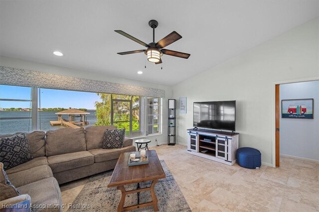 living area featuring baseboards, ceiling fan, a wealth of natural light, and lofted ceiling