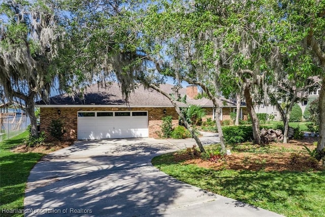 single story home with an attached garage, concrete driveway, and brick siding