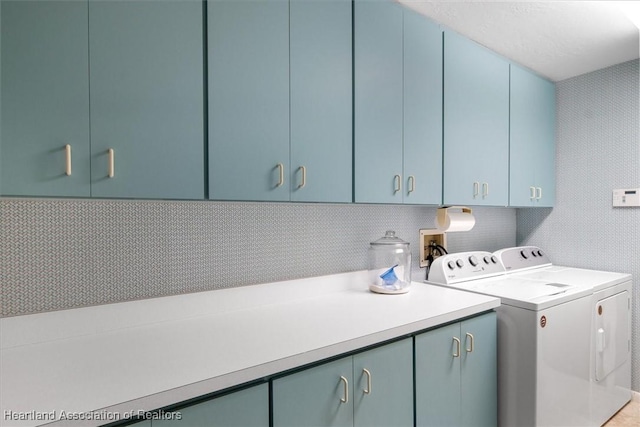 washroom with washing machine and dryer and cabinet space