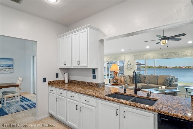 kitchen with a ceiling fan, dishwasher, a sink, white cabinets, and dark stone counters