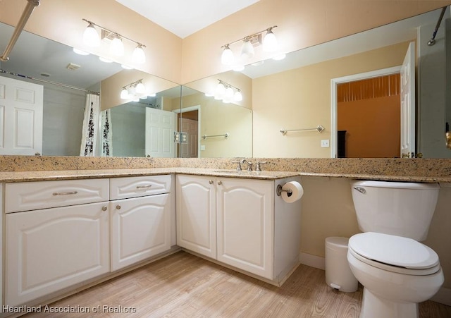 bathroom featuring hardwood / wood-style flooring, vanity, toilet, and walk in shower