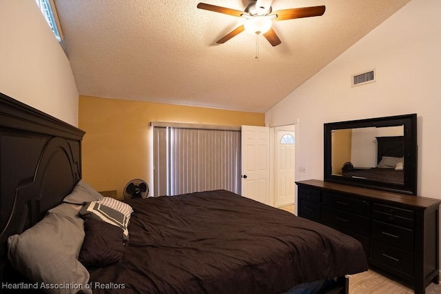 bedroom featuring a textured ceiling, ceiling fan, and lofted ceiling