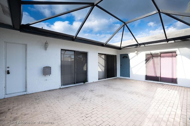 view of patio with glass enclosure