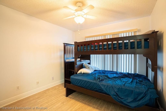 bedroom featuring wood-type flooring, a textured ceiling, and ceiling fan