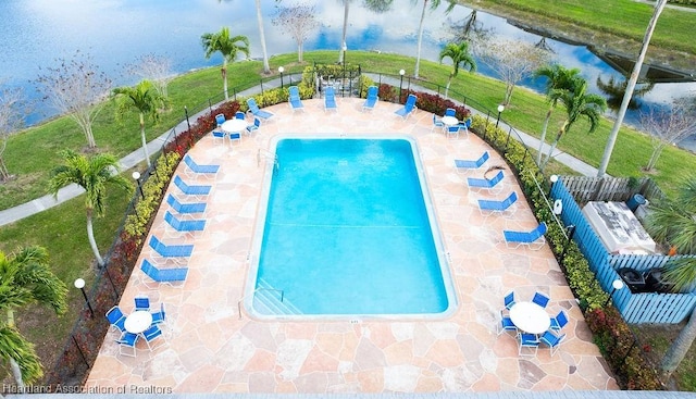 view of swimming pool with a water view and a patio