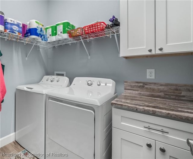 laundry area featuring cabinets, washing machine and dryer, and light wood-type flooring