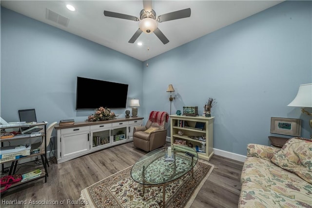 living room with wood-type flooring and ceiling fan