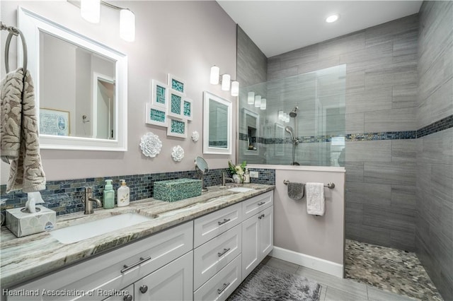 bathroom with vanity, backsplash, and tiled shower