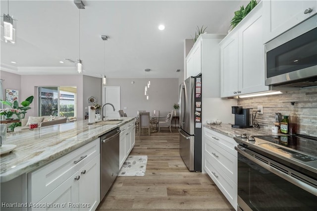 kitchen with white cabinetry, sink, decorative light fixtures, and stainless steel appliances