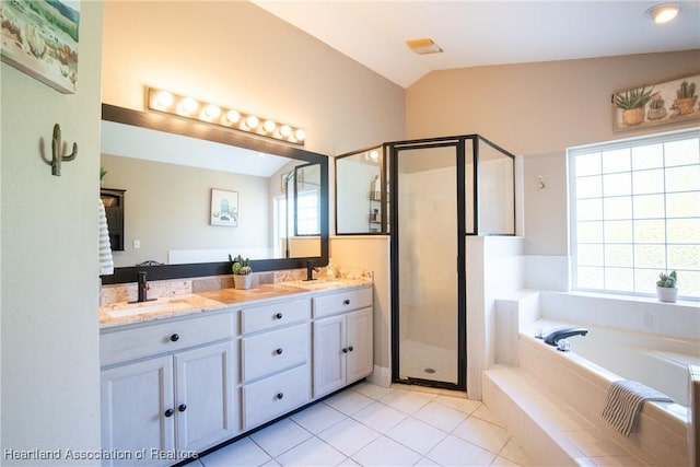 bathroom with a garden tub, double vanity, lofted ceiling, a sink, and a shower stall