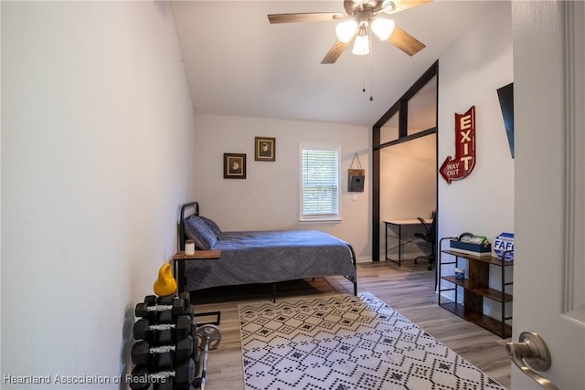 bedroom featuring lofted ceiling, a ceiling fan, and wood finished floors