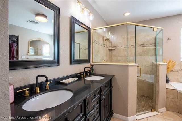 bathroom with a garden tub, tile patterned flooring, a sink, and a shower stall