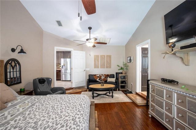 bedroom with visible vents, a ceiling fan, lofted ceiling, dark wood-style flooring, and stainless steel refrigerator with ice dispenser