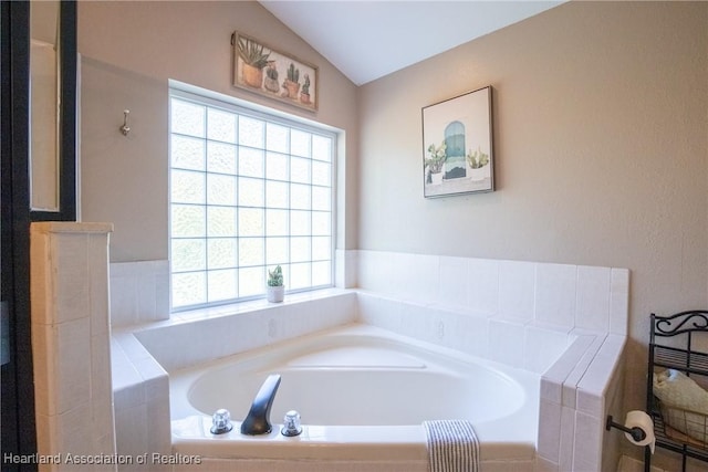 full bathroom with lofted ceiling and a bath