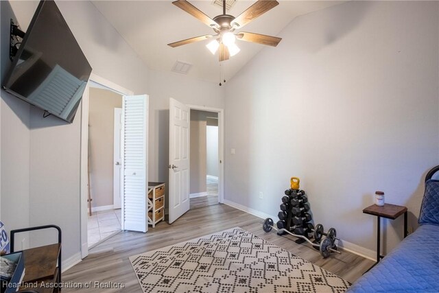 bedroom featuring baseboards, vaulted ceiling, visible vents, and light wood finished floors