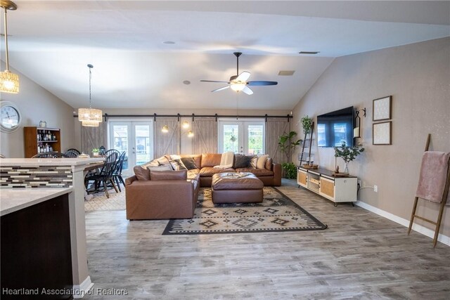 living room with baseboards, ceiling fan, wood finished floors, vaulted ceiling, and french doors