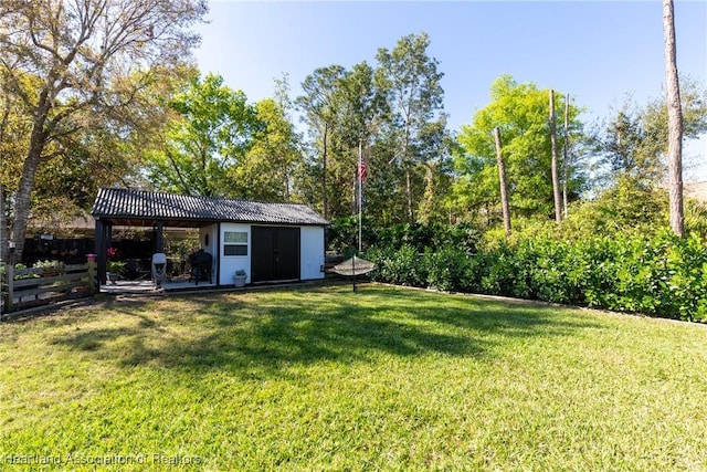 view of yard with fence and an outdoor structure