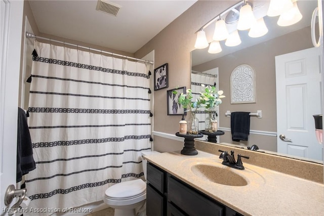 bathroom with toilet, vanity, visible vents, and a shower with curtain