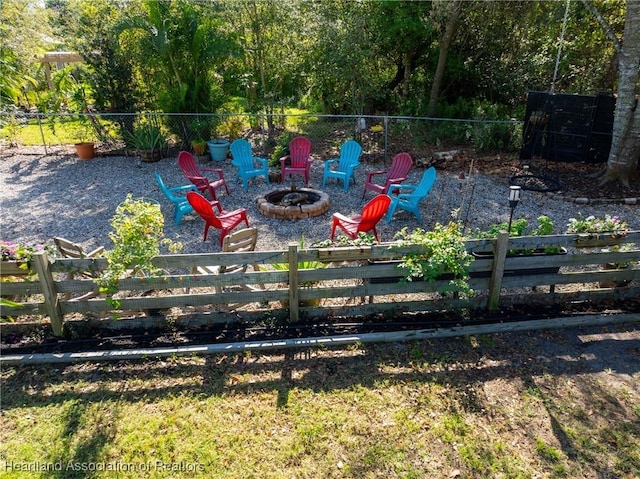 view of yard featuring an outdoor fire pit and fence