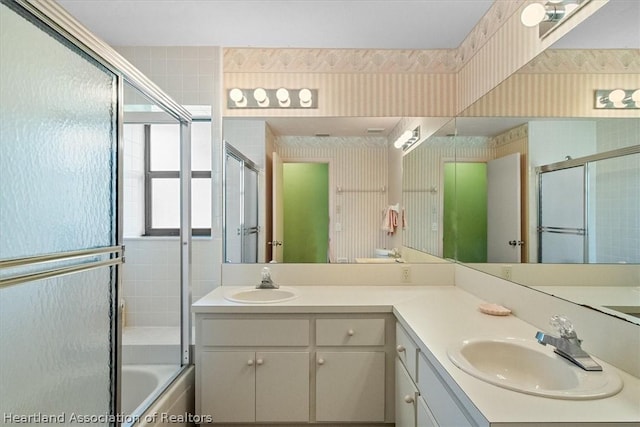 bathroom featuring vanity and bath / shower combo with glass door