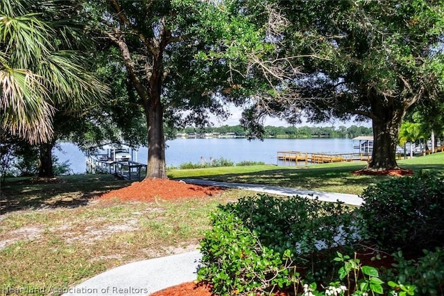 surrounding community with a water view and a dock