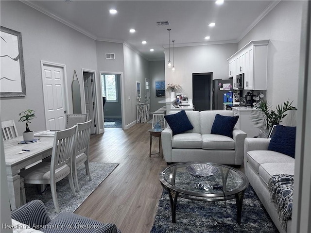 living room featuring light hardwood / wood-style flooring and crown molding