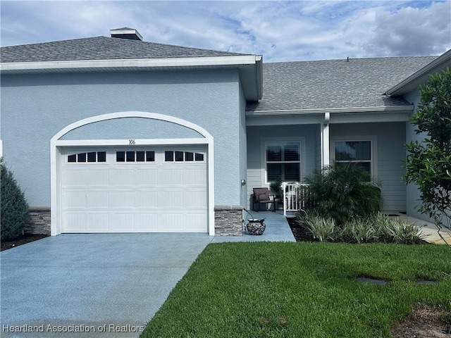 view of front of property with a front lawn, a porch, and a garage