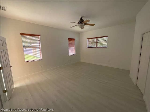 empty room with light wood-type flooring and ceiling fan