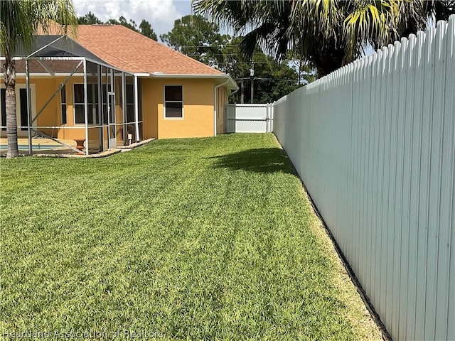 view of yard with a lanai and a swimming pool