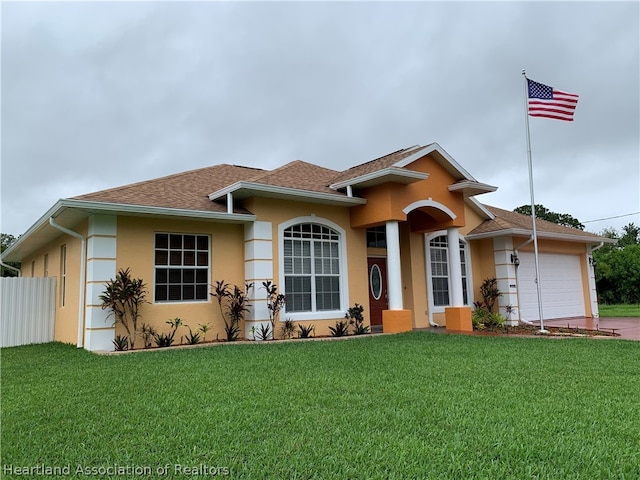 view of front of home with a front yard and a garage