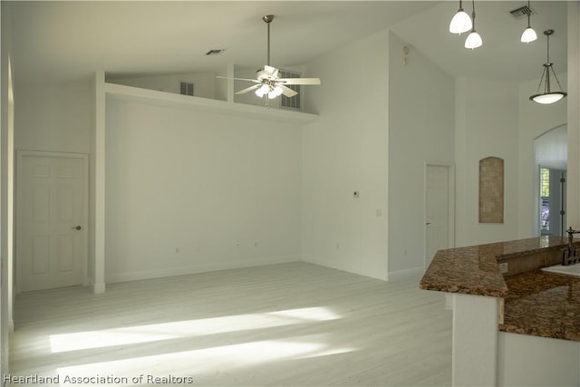 interior space with ceiling fan, light hardwood / wood-style flooring, high vaulted ceiling, and sink