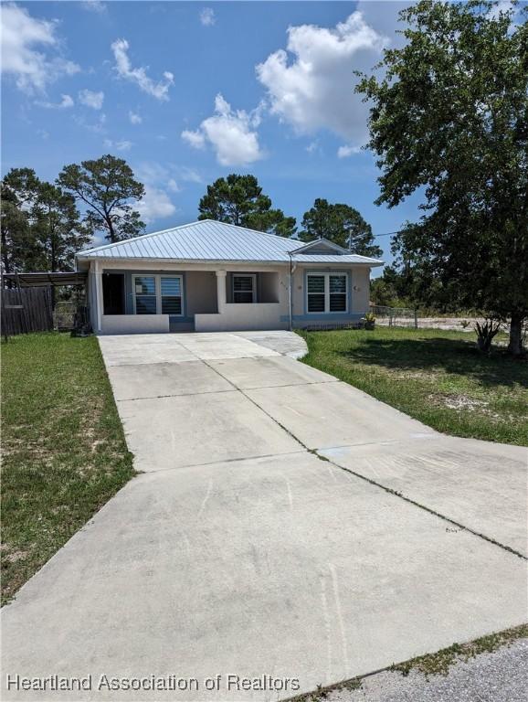 2146 Hartman Rd, Avon Park, FL 33825 - ranch-style house featuring driveway, metal roof, and stucco siding