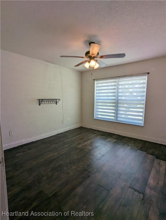 2146 Hartman Rd, Avon Park, FL 33825 - spare room featuring ceiling fan, baseboards, and dark wood-style floors