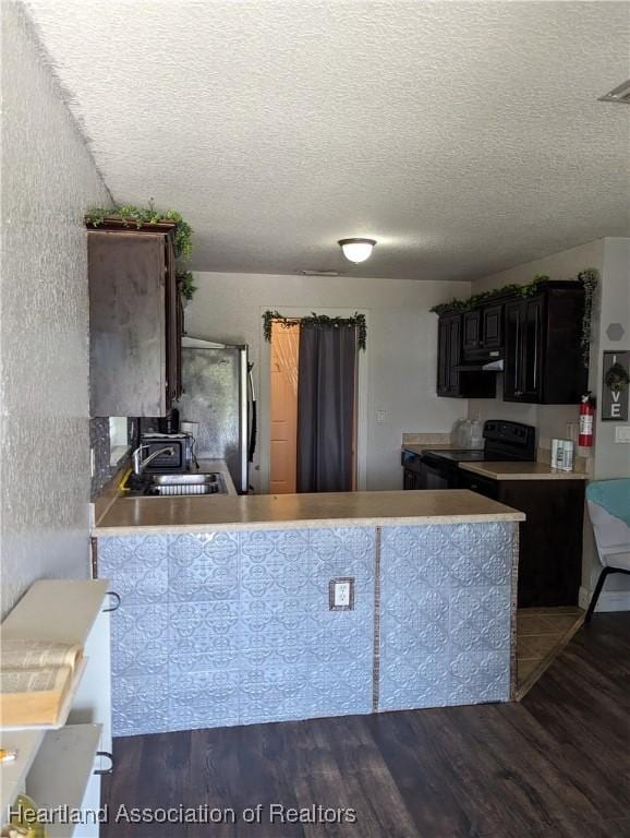 2146 Hartman Rd, Avon Park, FL 33825 - kitchen with electric range, a sink, wood finished floors, freestanding refrigerator, and a textured ceiling
