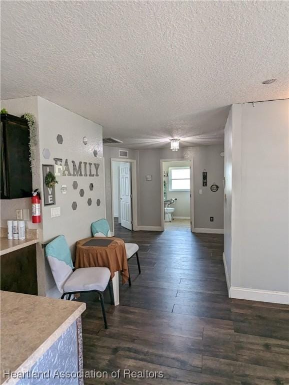 2146 Hartman Rd, Avon Park, FL 33825 - dining room with a textured ceiling, dark wood finished floors, and baseboards