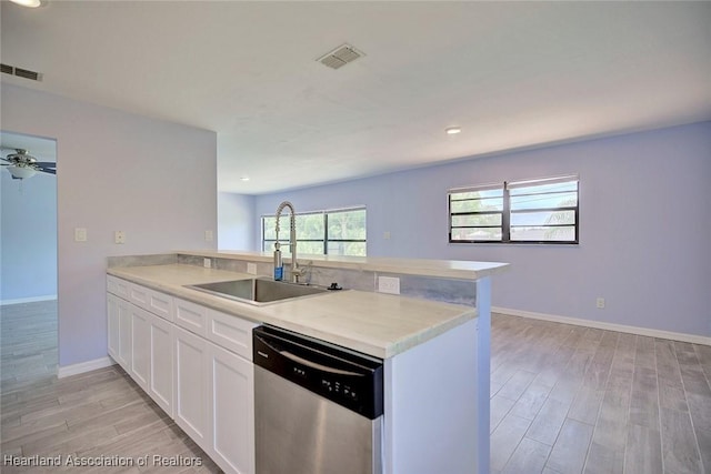 kitchen featuring light hardwood / wood-style floors, white cabinetry, stainless steel dishwasher, sink, and kitchen peninsula