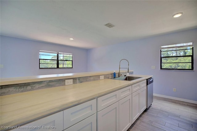 kitchen featuring sink, white cabinets, dishwasher, and light hardwood / wood-style floors