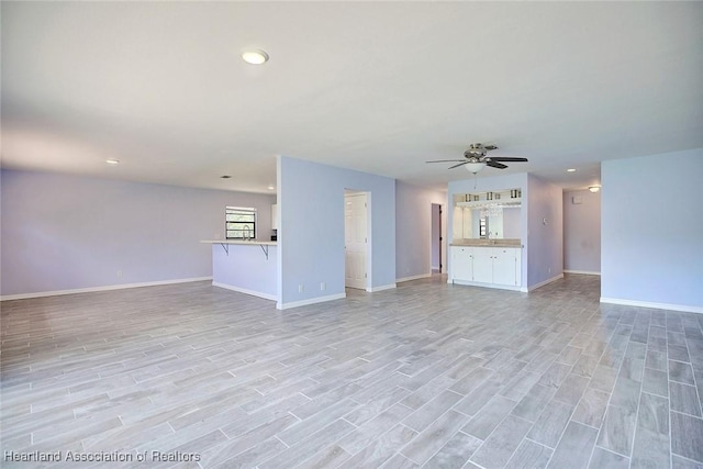 unfurnished living room with ceiling fan and light hardwood / wood-style flooring