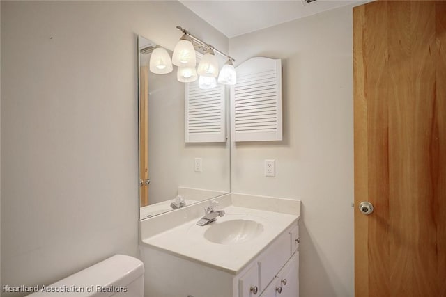 bathroom featuring toilet and vanity