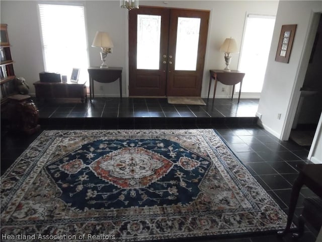 entryway with french doors and dark tile patterned flooring