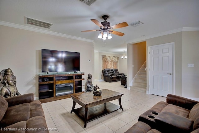 tiled living room with crown molding, ceiling fan, and a fireplace