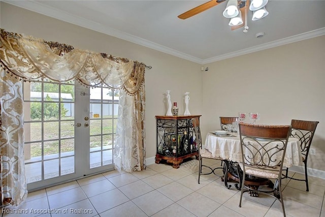 tiled dining room with french doors, ceiling fan, and crown molding