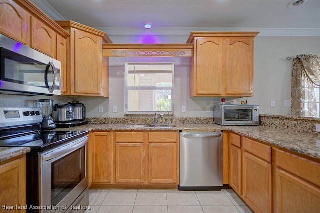 kitchen with sink, crown molding, appliances with stainless steel finishes, light stone counters, and light tile patterned flooring