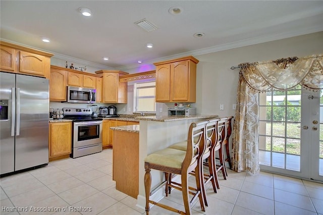 kitchen featuring a breakfast bar, ornamental molding, kitchen peninsula, stainless steel appliances, and light stone countertops