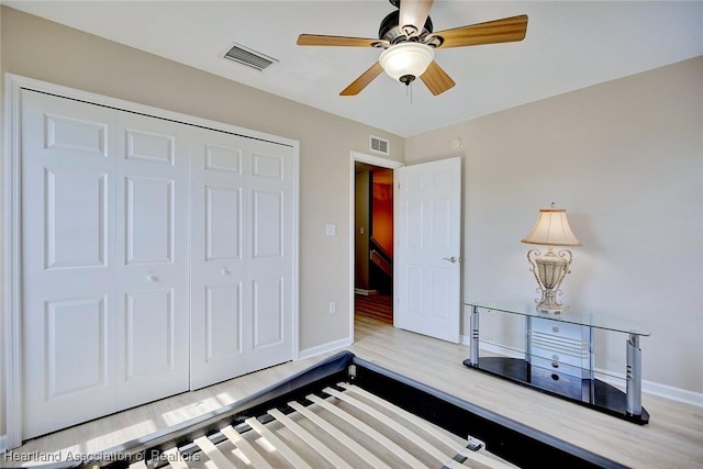 bedroom with ceiling fan, a closet, and light hardwood / wood-style flooring