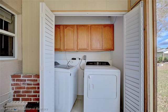 clothes washing area featuring cabinets and independent washer and dryer